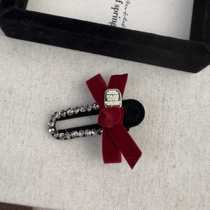Detail of vintage velvet bow hair clip with sparkling rhinestones and metal center piece