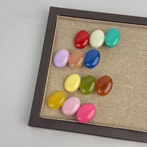 Detail of 11 colorful oval hair clips with smooth glaze finish in a wooden display tray