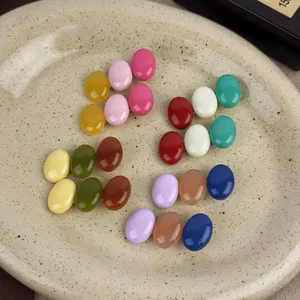 Macro shot of 12 colors candy-shaped resin hair clips arranged on a ceramic plate
