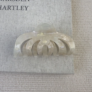 Détail macro d'une pince à cheveux en acétate blanc crème avec texture marbrée