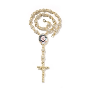 Dettaglio collana dorata con foto, crocefisso ghiacciato e ciondolo rotondo personalizzato