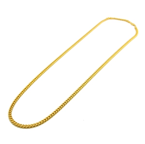Dettaglio della collana a catena cubana placcata in oro con maglie lucide su sfondo bianco