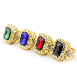 Detail showing four hip-hop gold square rings with green, blue, red, and black gemstones