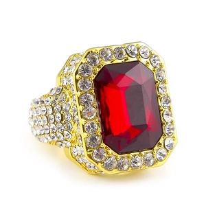 Macro shot of hip hop square gold plated ring with large red stone and micro paved crystals