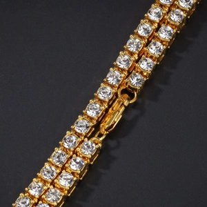 Detalle macro de una cadena de tenis de doble fila con acabado dorado y circonitas