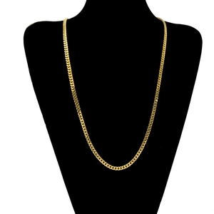 Dettaglio di una collana a catena cubana dorata con maglie lisce su un supporto da collo