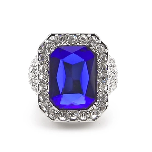 Macro shot of large rectangular blue gemstone ring with pave white diamonds on silver band