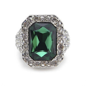 Macro detail of emerald cut green gemstone ring with pavé set side stones in silver