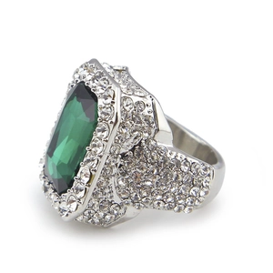 Macro side view of silver alloy ring with large emerald-cut green stone and pavé rhinestones