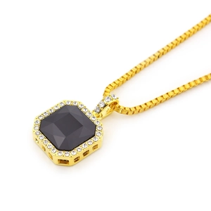 Makroansicht der goldenen Boxkette und Anhänger mit schwarzem Edelstein und Diamanten