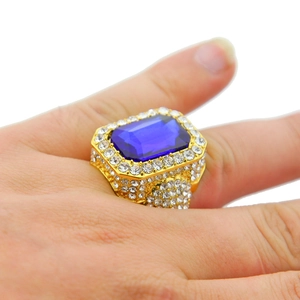 Detail of hip hop gold ring with large blue rectangle gem and pavé white diamonds