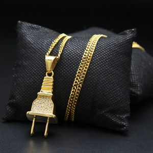 Gros plan du pendentif hip hop en forme de prise dorée sertie de strass brillants