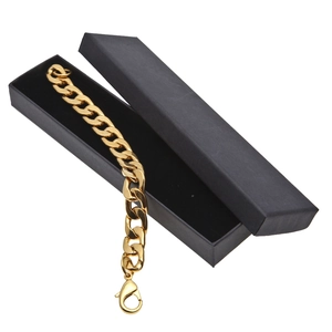 Detail eines klobigen goldenen Panzerkettenarmbands mit Karabiner auf schwarzer Box