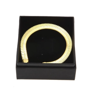 Nahaufnahme einer goldenen Schlangenkette in einer minimalistischen schwarzen Schmuckbox
