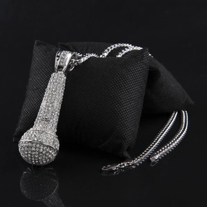 Gros plan du pendentif microphone hip hop argenté avec strass brillants et chaîne cubaine