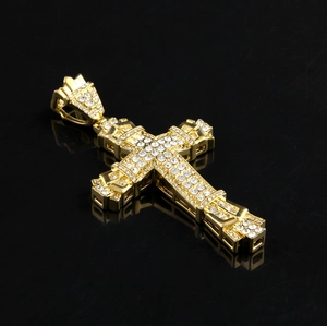 Makrodetail eines Hip-Hop-Kreuzanhängers mit glänzender Goldbeschichtung und Zirkonsteinen