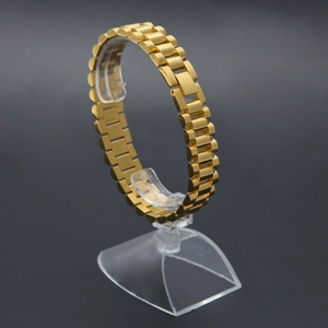 Detalle de la correa de reloj en acero inoxidable dorado con eslabones y cierre plegable