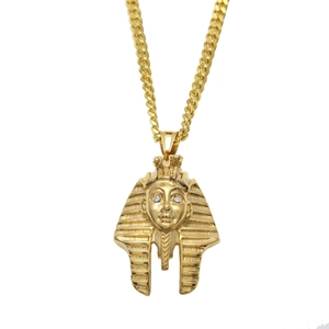 Detailed close-up of golden Egyptian Pharaoh pendant with cubic zirconia eyes on Cuban chain