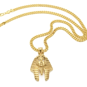 Macro detail of golden Egyptian Pharaoh Tutankhamun pendant with crystal eyes