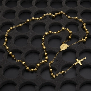 Détail d'un collier chapelet doré avec croix et médaillon, perles en acier inoxydable