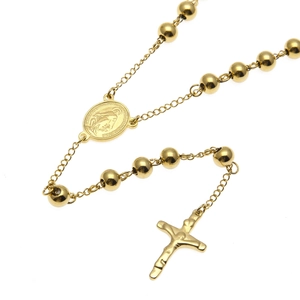 Vue détaillée du collier chapelet doré à billes avec médaille et croix pendante