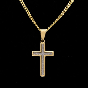 Détail du pendentif croix hip-hop avec texture argentée scintillante et cadre doré