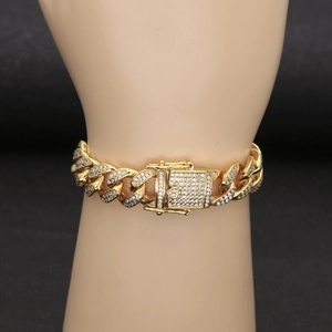 Detail of 13mm gold plated iced out cuban link bracelet on wrist with zircon stones