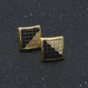 Macro view of square earrings with black and white zircon stones in gold plating