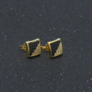 Macro shot of square gold-plated stud earrings with black and white pavé zircon stones