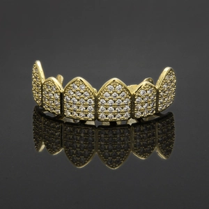 Detail of hip hop grillz featuring gold plated metal and micro paved clear zircons