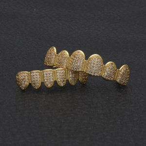 Macro shot of gold hip hop grillz with pavé set cubic zirconia on black leather