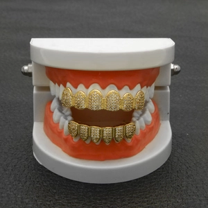 Close-up of hip hop gold grillz with sparkling zircons on a white dental model