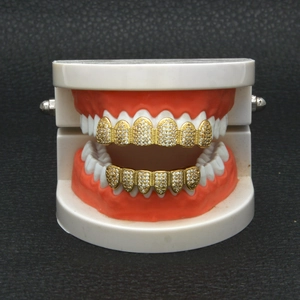 Macro detail of gold plated hip hop grillz set with micro paved zircon on dental model