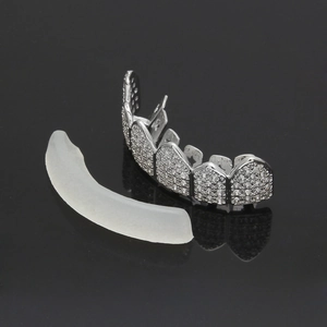 Close-up of silver-tone hip-hop grillz with cubic zirconia and clear silicone fixing bar