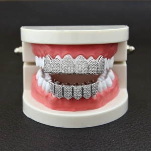 Macro shot of silver hip hop grillz with shimmering pavé cubic zirconia on model teeth