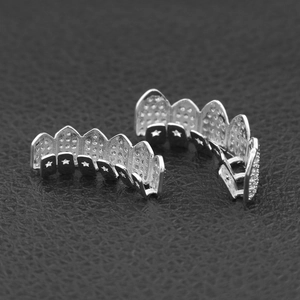 Macro detail of silver hip hop grillz with star cutouts and diamond-like texture