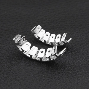 Macro shot of silver hip hop grillz with star cut-outs on black leather texture