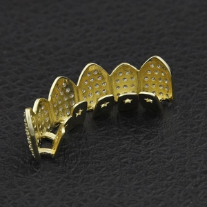 Macro shot of hip hop gold grillz with six teeth and sparkling micro-pave zircons