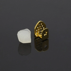 Macro-detail van gouden enkele tand grillz met zirkonia en ster-uitgesneden patroon