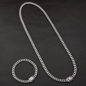 Detail view of silver Cuban link necklace and bracelet set with textured box clasp
