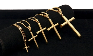 Vue détaillée de cinq pendentifs croix dorés en différentes tailles sur présentoir