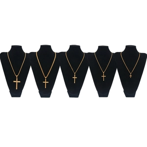Cinq pendentifs croix en or de différentes tailles sur des supports noirs