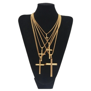 Ensemble de quatre pendentifs croix dorés de tailles variées sur présentoir noir