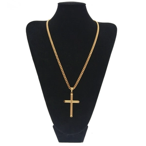 Gros plan détaillé du pendentif croix dorée sur buste noir avec une chaîne cubaine