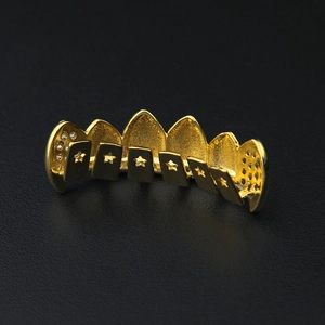 Macro shot of 18k gold plated hip hop grillz with hollow star design and CZ stones