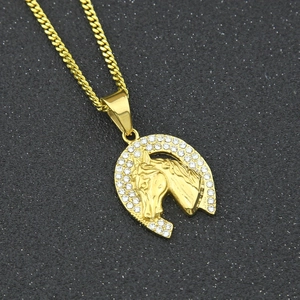 Detailed macro view of a gold-plated horse head pendant with sparkling white zircons