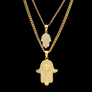 Detailed macro view of gold-plated Hamsa Hand pendants with sparkling zirconia stones