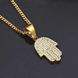Detailed close-up of golden Hamsa Hand pendant necklace with sparkling crystal inlay