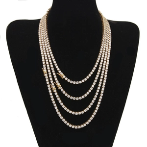 Golden 4mm tennis necklace set with round zirconia stones on black display stand