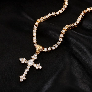 Dettaglio del ciondolo a croce dorata con zirconi AAA su una collana stile tennis